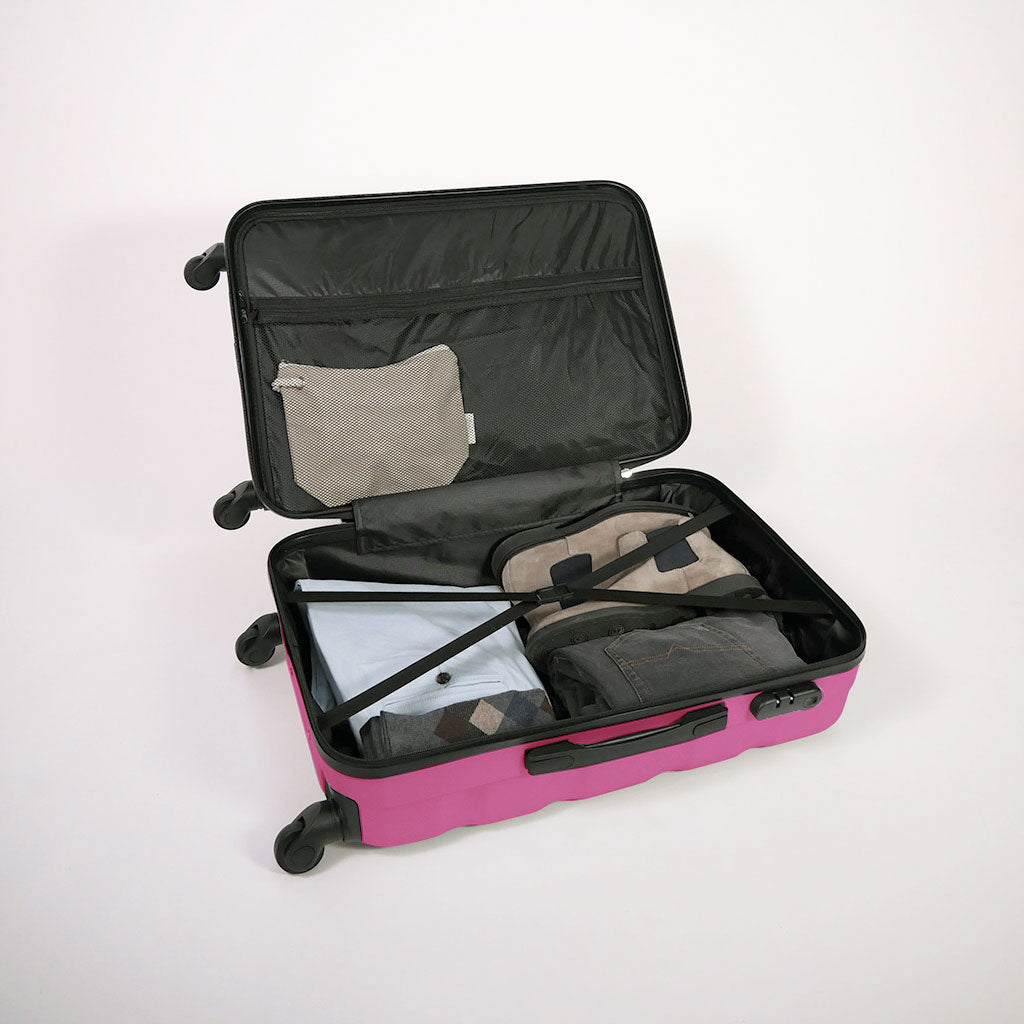 Valigia fucsia aperta piena di vestiti, con dettaglio di cinghie estensibili elastiche, doppio fondo e tasca con zip