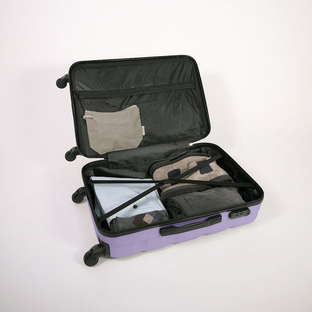Valigia lilla aperta piena di vestiti, con dettaglio di cinghie estensibili elastiche, doppio fondo e tasca con zip