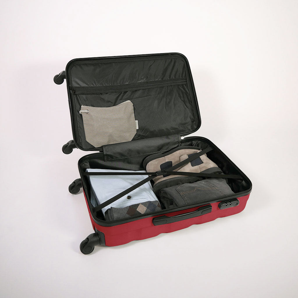 Valigia rossa aperta piena di vestiti, con dettaglio di cinghie estensibili elastiche, doppio fondo e tasca con zip