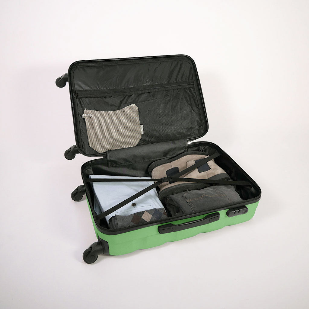 Valigia verde aperta piena di vestiti, con dettaglio di cinghie estensibili elastiche, doppio fondo e tasca con zip