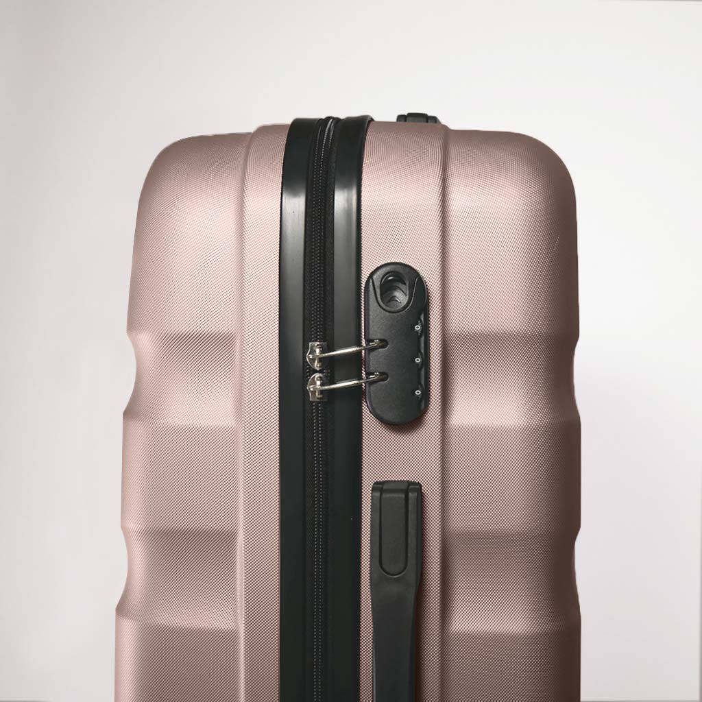 Lato valigia rigida oro rosa dettaglio lucchetto a combinazione con chiusura tramite zip